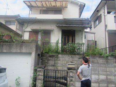 空き家の状況を外から観察している男性の写真