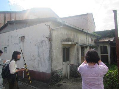 空き家の状況確認のため撮影を行う女性の写真