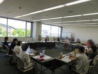 四角枠に並べた机に座り、ディスカッションが行われている様子の写真