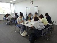 モノトーンを基調とした部屋で対談を行う参加者たちの写真