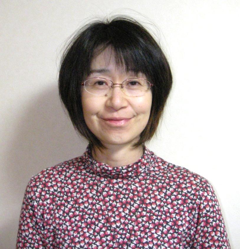 小花柄のトップス姿で眼鏡をかけてほほ笑む三野敬子さん
