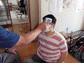 主催者側の男性が参加者の検温を行う様子の写真