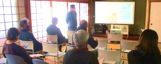 スクリーンの映像を見る参加者