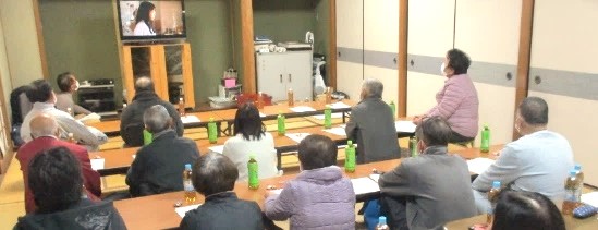 スクリーンの映像を見る参加者