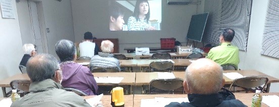 スクリーンの映像を見る参加者