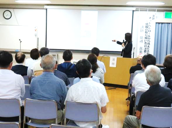 パワーポイントに指示棒を差しながら話す講師の様子