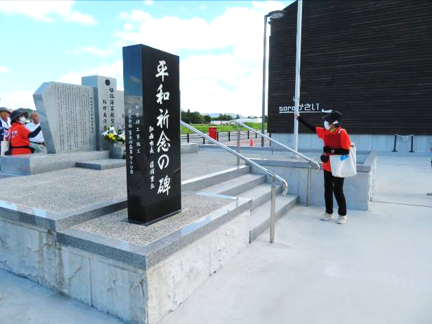 青空の下、平和祈念の碑と書かれた、黒い長方形の石碑の写真
