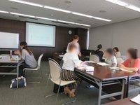 机に座り話し合いを行う参加者たちの写真