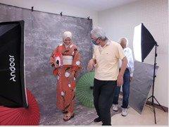 浴衣姿でほほ笑むインドネシア人女性とポーズのアドバイスをする写真クラブの男性