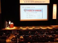 プロジェクターに各種計画が映し出され、講演が行われている写真