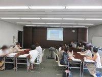並列に長机を並べて、向かい合うような形で椅子に座る参加者たちの写真