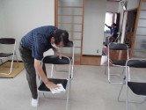 交流会参加者が使用する椅子の消毒を行う男性の写真