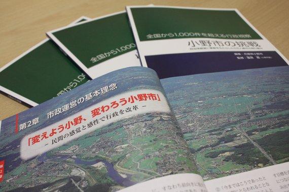 表に置かれた3冊の小野市の挑戦と、1冊の見開きの写真