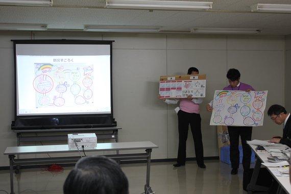 職員2人がポスターを持って前で発表している自主研究グループ発表会の様子の写真