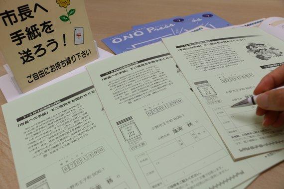 テーブルの上に置かれた広報おのと市長の手紙に記入をしようとしている写真