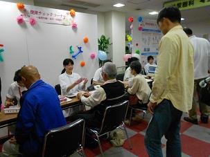 ブースで看護師と向かい合って話している人たちの写真