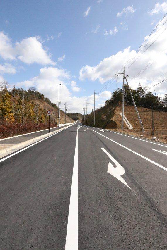 まっすぐ伸びている3車線の新都市中央線の道路の写真