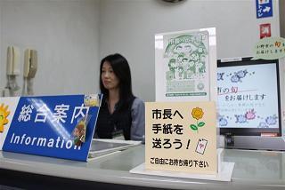 「ご自由にお持ち帰り下さい」と書かれた市長への手紙が置かれている市役所の総合案内窓口の写真