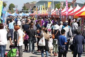 様々な屋台が出ている間を沢山の人が行き交っている写真