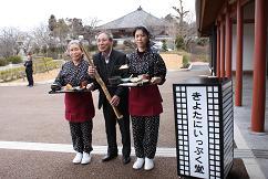 きよたにいっぷく堂の前で3人の男女が料理などを手に持ち立っている画像