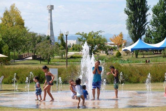 水着を着た子供たちが噴水で水遊びをしている写真