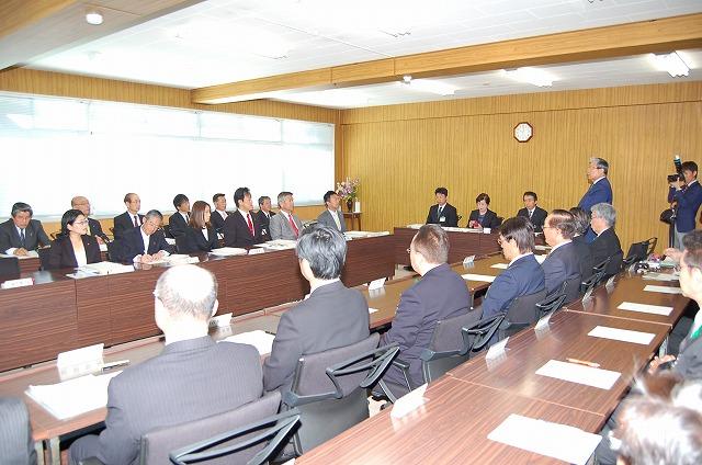 向かい合った長いテーブルに着席し、市議会臨時議会が開かれている様子の写真