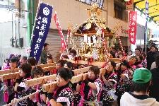大きな神輿を女性たちで担いでいる女性神輿の写真