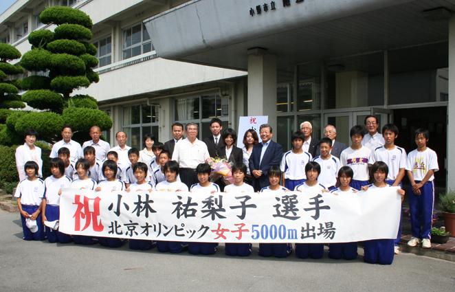 「祝 小林祐梨子 北京オリンピック女子5000メートル出場」と書かれた旗を持った学生と教師たちの集合写真