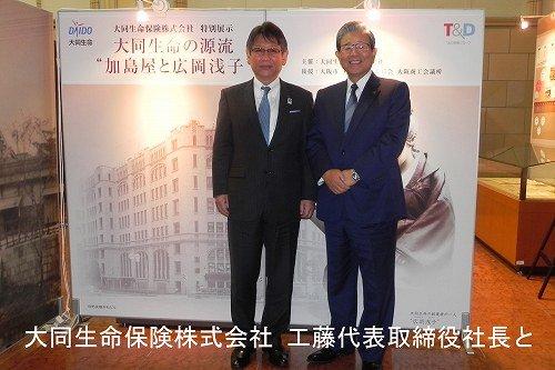 特別展示『大同生命の源流“加島屋と広岡浅子”』のパネルを前に記念撮影に応じる、蓬莱市長と工藤代表取締役社長の写真