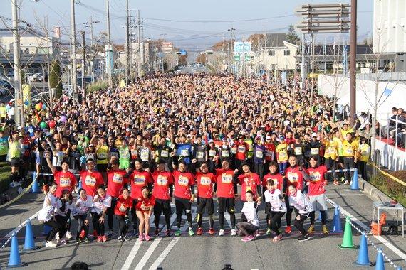 沢山のランナーと観客が正面を向いて笑っている集合写真