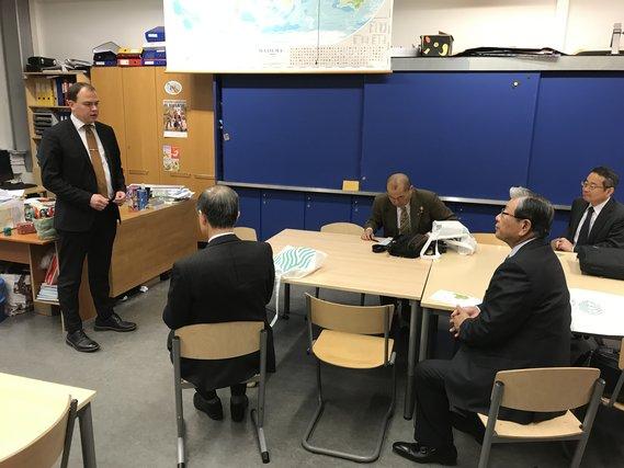 ヴィヒチィ市の小中一貫教育の現場で説明をうける全国市長会欧州都市行政調査団の写真