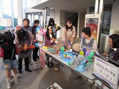 ブースで子供と一緒にバルーンアートをしている写真