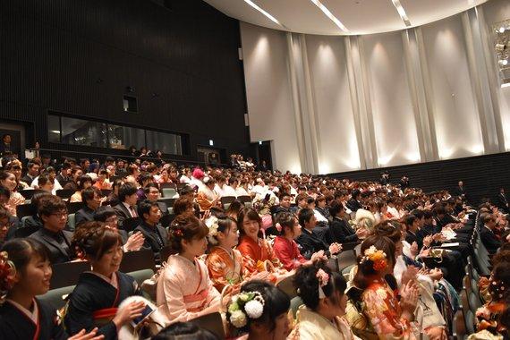 会場に座っている振袖やスーツを着た沢山の新成人たちの写真