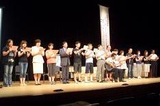 ステージの上に15名ほどの人が並び、十二単を演じている写真