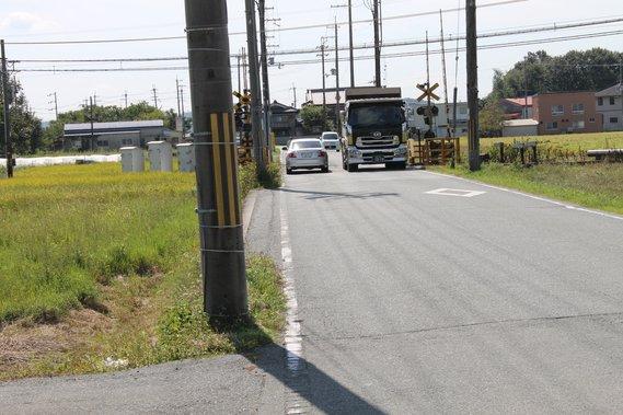 神戸電鉄踏切を車両が通行している様子の写真
