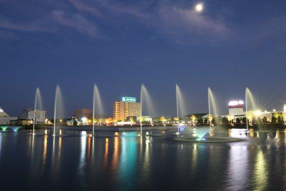 噴水が上がりライトアップされた夜のソロ池の写真