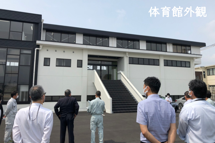 工事改修を終えた小野南中学校の体育館外観を市長が視察している様子