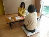 2人の女性が机に向かって対面で話している様子の写真