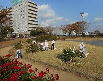 赤、白、ピンクと色別に分けられたバラをそれぞれ分かれて手入れをする管理員たちの写真