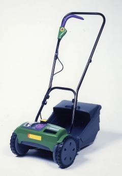 2つの車輪の機器の上に紺色の細長いフレームがつき、脇には刈った芝を取り込める受け皿が付いている様子のコードレス電動芝刈機 シバクリーンの写真