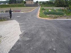 アスファルトで舗装された農道付近の通路の写真