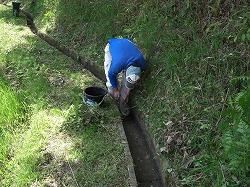 水路の補修をする人の写真