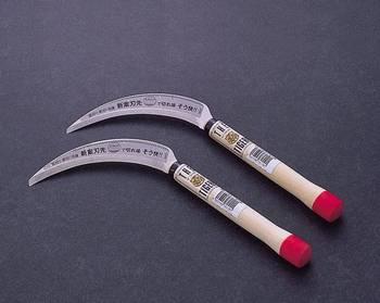 赤と木目の入った持ち手に、文字が入った刃が装着されている様子の稲刈・草刈鎌2本の写真