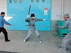武器を持った暴漢に対し、さすまたを使って暴漢の右足首と胴体を押さえつける様子の写真