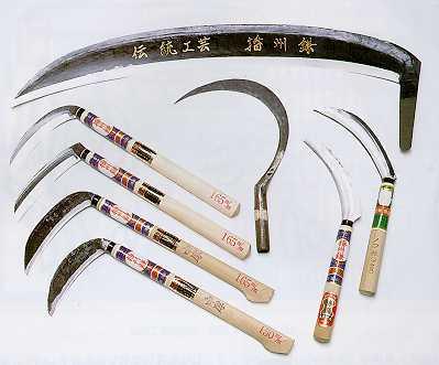 大きな刃に金色の文字が彫られた鎌と大小さまざまな鎌がきれいに並べられた写真