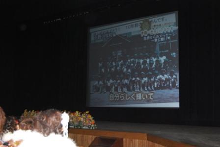 前方スクリーンには集合写真が映し出され、「自分らしく輝いて」の字幕があるビデオレター映像の写真。