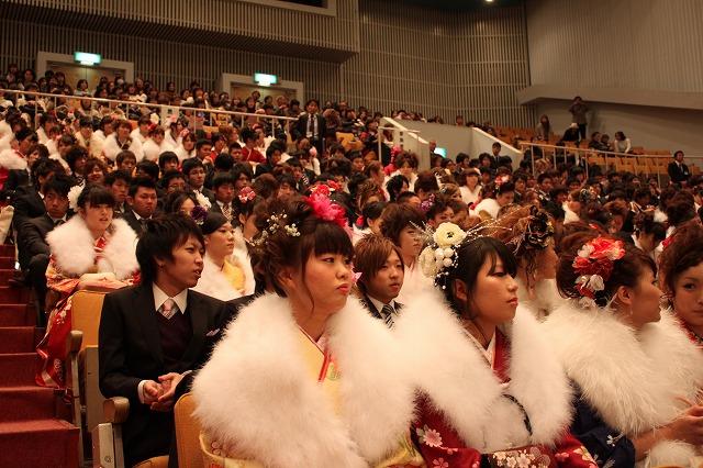 壇上の話を聞く観客席の新成人たちの写真