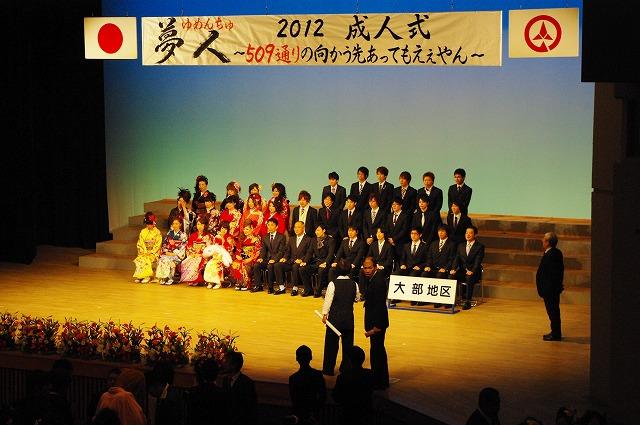 壇上で記念撮影をする新成人たちと市長の写真