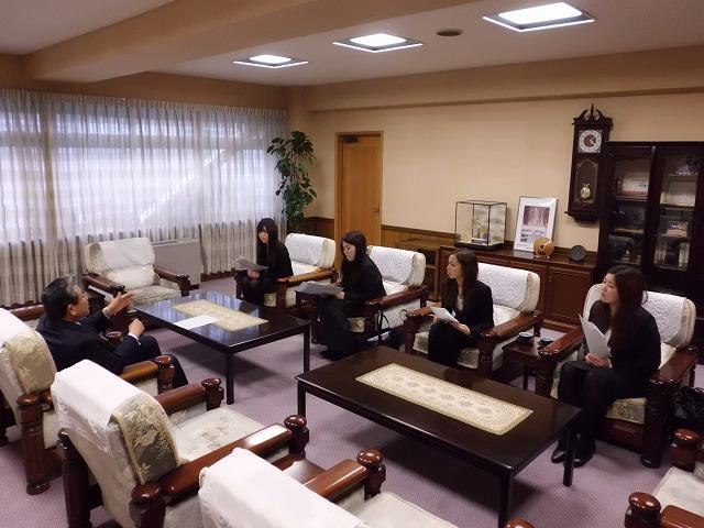 茶色の市長室でテーブルを挟んで成人式の説明をしている写真