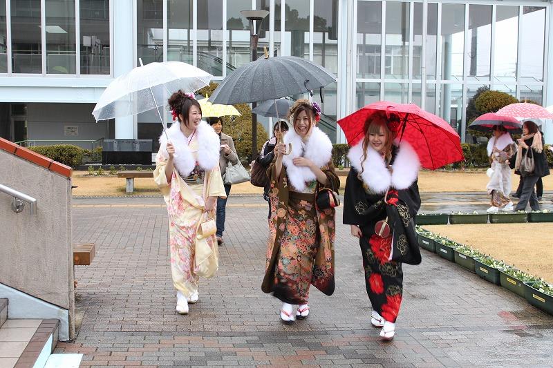 雨の中傘を差し歩く晴れ着姿の女性、続々と集まる新成人達の写真。